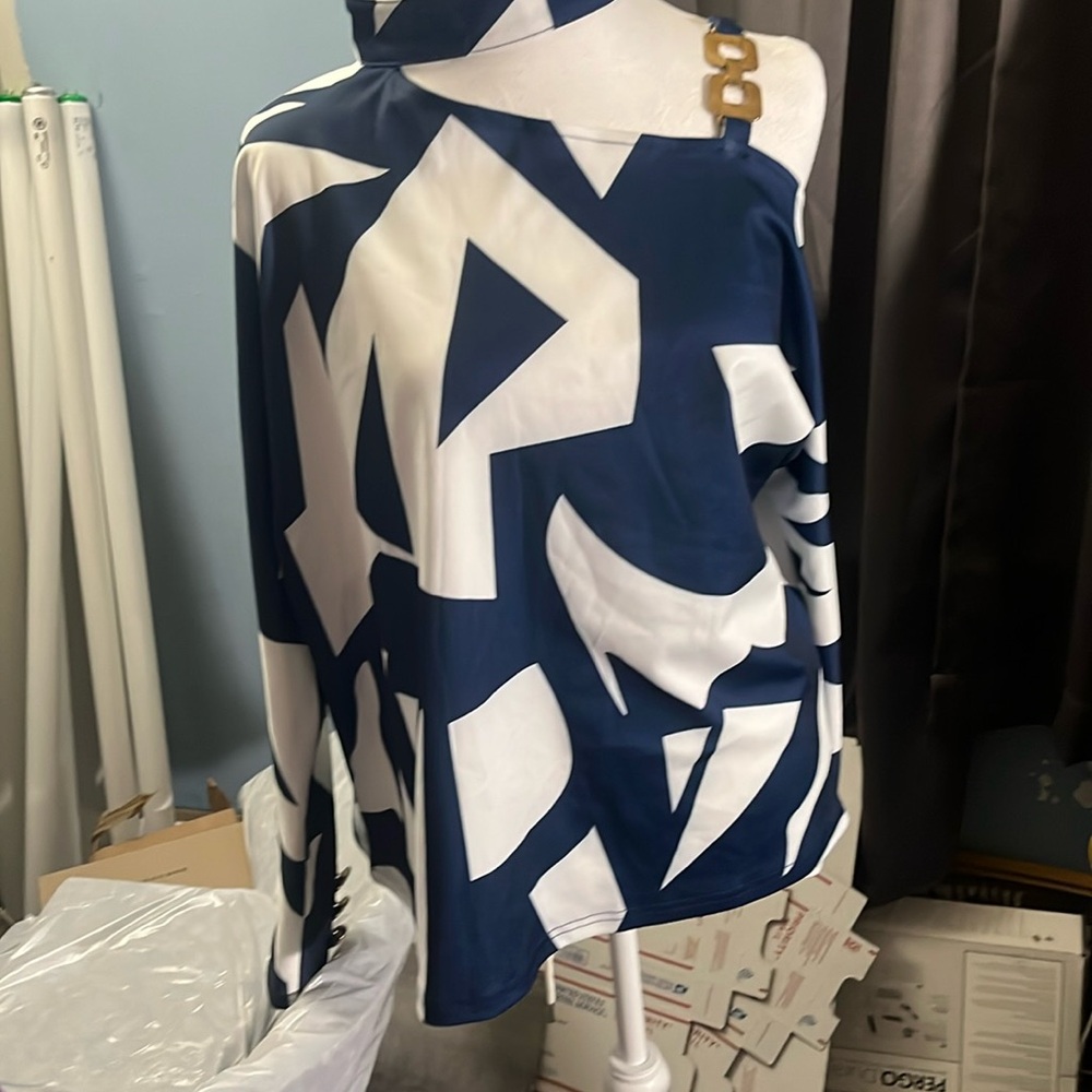 Buttons at back of neck. Cold shoulder blouse. Long sleeve.